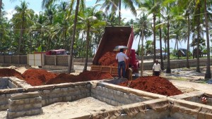 Site manager Pradeep supervising unloading the red sand